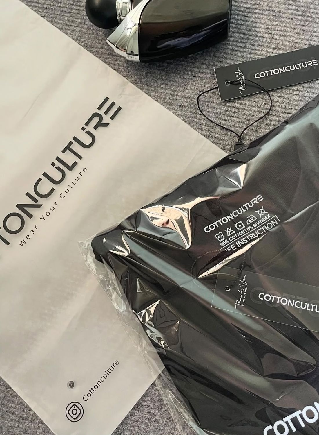 A Cotton Culture tee sealed in its bag with the hang tag